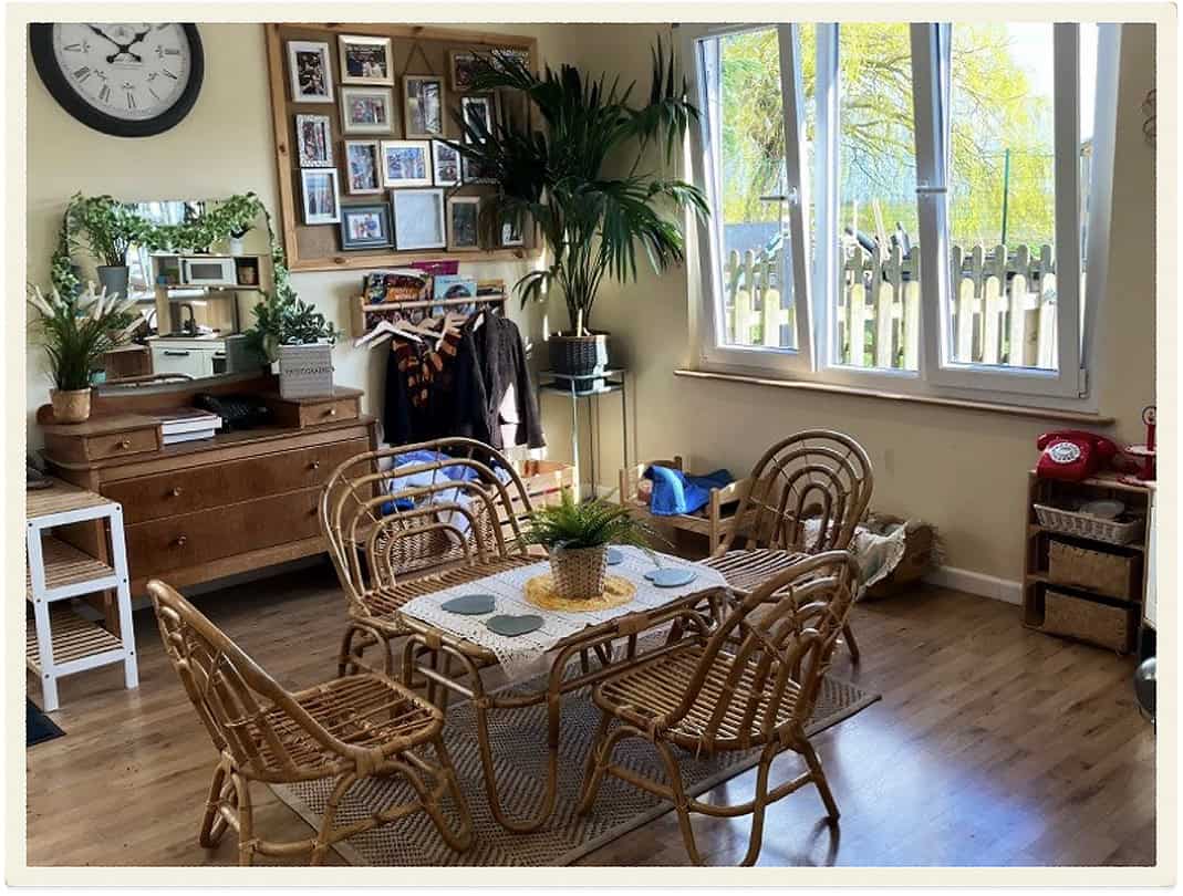 Bright indoor play area with wooden furniture and large windows at Lancaster Lodge Childcare.