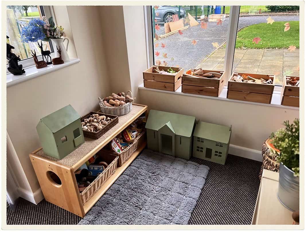 Indoor children's play area with wooden toys and storage boxes at Lancaster Lodge Childcare.