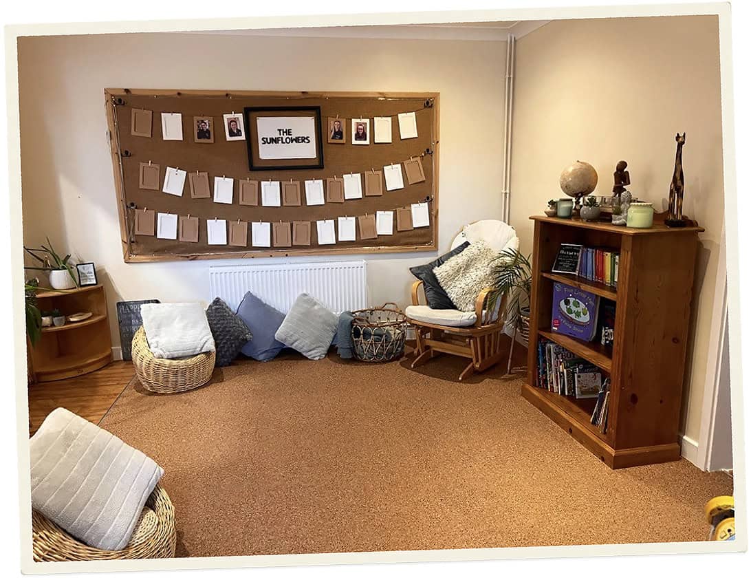 Cozy reading corner with cushions, bookshelf, and decorative items at Lancaster Lodge Childcare.