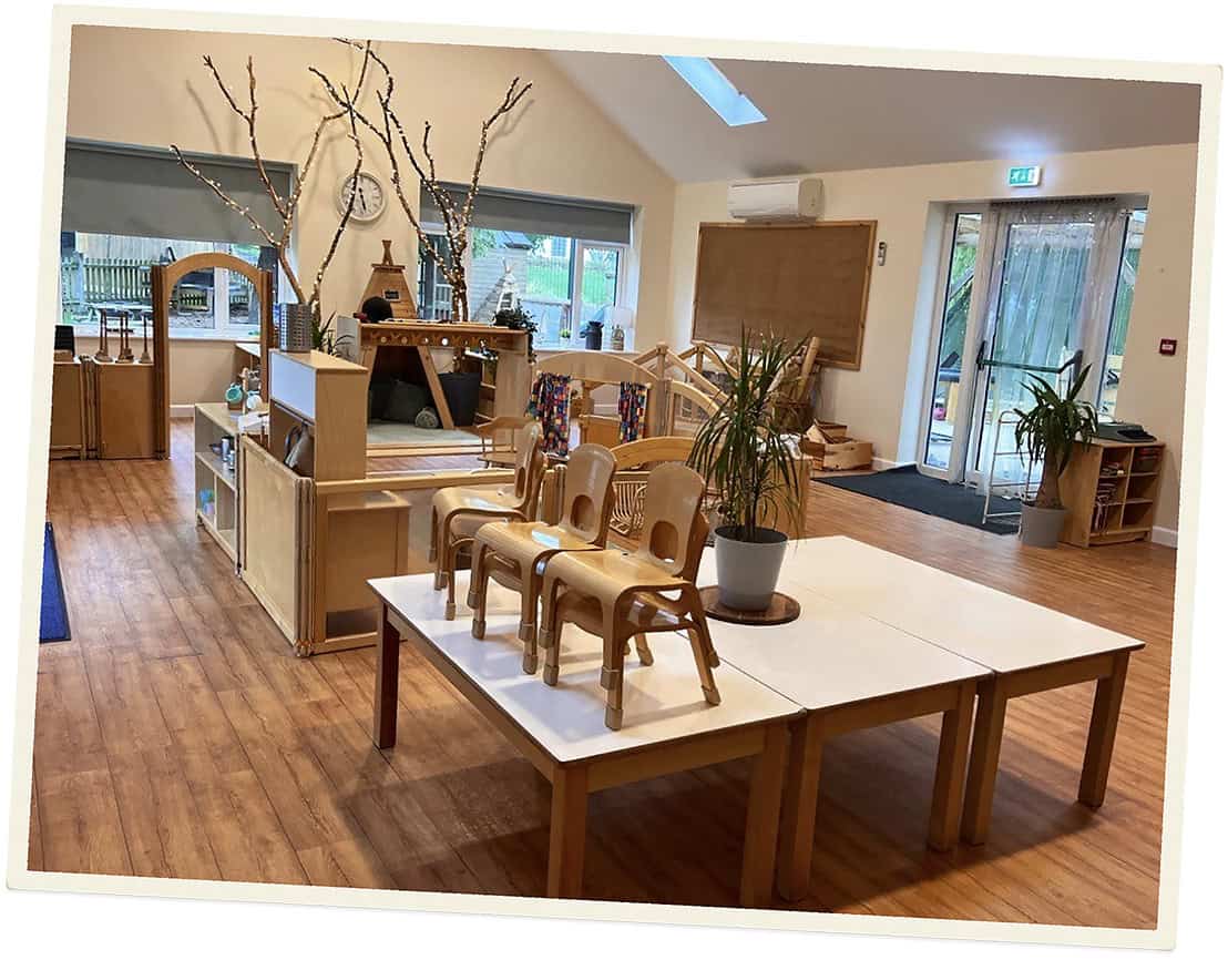 Bright childcare room with wooden furniture and natural light at Lancaster Lodge.