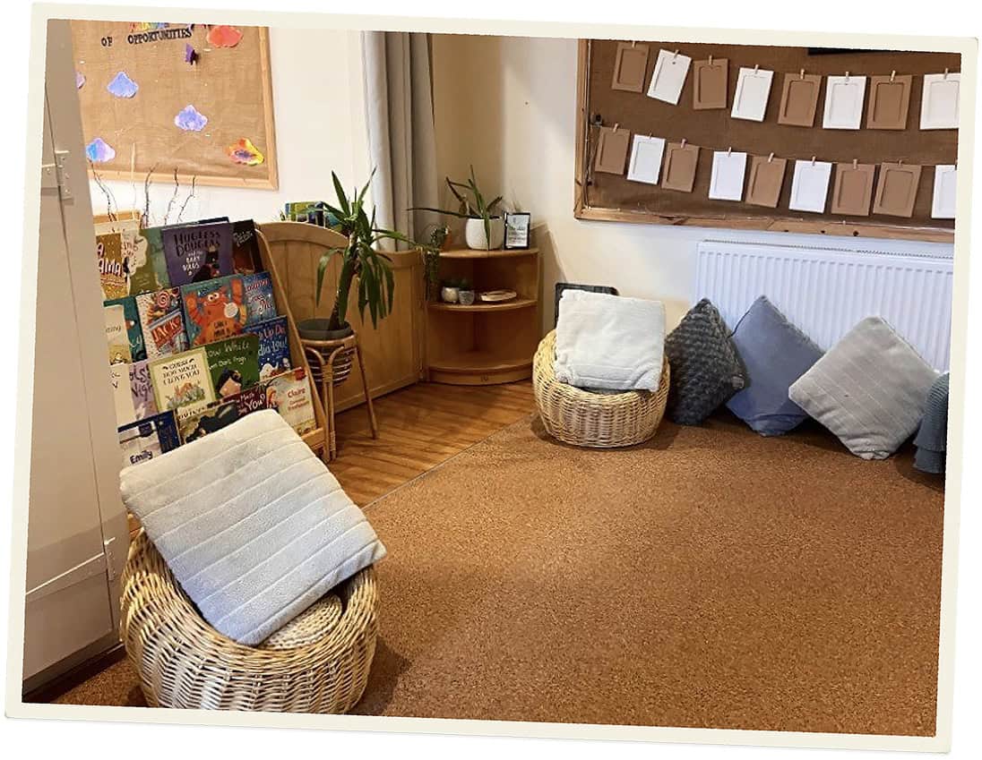 Cozy reading corner with wicker chairs and cushions at Lancaster Lodge Childcare.